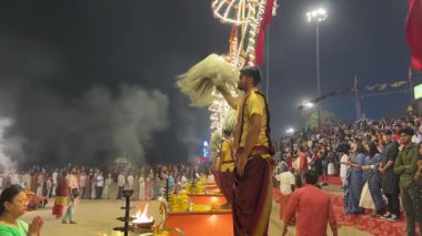 Varanasi, Uttar Pradesh, Hindistan - 12 Mart 2025: Ganga aarti, Dashashwamedh ghat 'ta akşam saatlerinde Hint ritüelleri ile geleneksel elbise içinde nehir çeteleri yakınlarındaki ışık ve dekorasyon videosu.