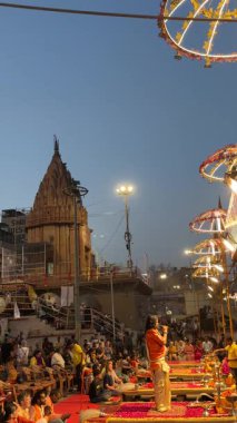 Varanasi, Uttar Pradesh, Hindistan - 12 Mart 2025: Ganga aarti, Dashashwamedh ghat 'ta akşam saatlerinde Hint ritüelleri ile geleneksel elbise içinde nehir çeteleri yakınlarındaki ışık ve dekorasyon videosu.