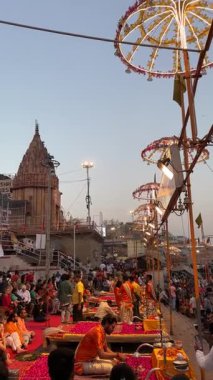 Varanasi, Uttar Pradesh, Hindistan - 12 Mart 2025: Ganga aarti, Dashashwamedh ghat 'ta akşam saatlerinde Hint ritüelleri ile geleneksel elbise içinde nehir çeteleri yakınlarındaki ışık ve dekorasyon videosu.