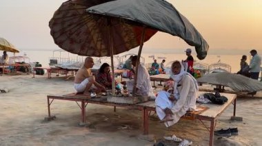 Hindistan 'da nehir keneviri bankasında oturan insanlar