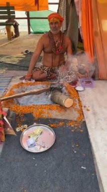 Varanasi, Uttar Pradesh, Hindistan - 11 Mart 2025: Masan Holi, Naga sadhu 'nun suratında ve vücudunda pirinçten küller olan videosu;.