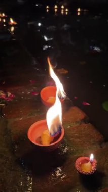 Ganga aarti, Ateş alevi ve gül ve kadife çiçekleri gece Ganga aarti sırasında Hint ayinlerini gerçekleştirmek için nehir gangalarında yüzüyorlar. Din konsepti üzerine 4k video.