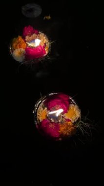 Ganga aarti, Ateş alevi ve gül ve kadife çiçekleri gece Ganga aarti sırasında Hint ayinlerini gerçekleştirmek için nehir gangalarında yüzüyorlar. Din konsepti üzerine 4k video.