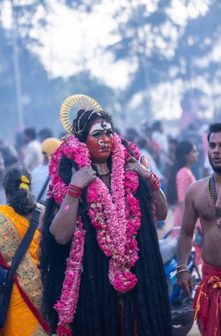 Kulashekharapatnam, Tamilnadu, Hindistan - 12 Ekim 2024: Yüzü boyalı ve tanrı karakteri gibi giyinmiş Hintli Hintli Hindu dindarın portresi kulasai dasara festivalinin ayinlerini gerçekleştirmek için.