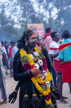 Kulashekharapatnam, Tamilnadu, Hindistan - 12 Ekim 2024: Yüzü boyalı ve tanrı karakteri gibi giyinmiş Hintli Hintli Hindu dindarın portresi kulasai dasara festivalinin ayinlerini gerçekleştirmek için.