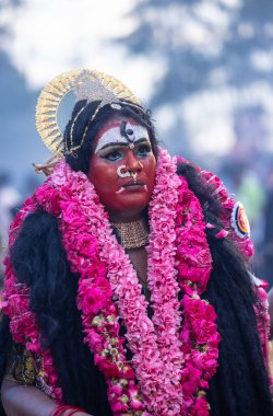 Kulashekharapatnam, Tamilnadu, Hindistan - 12 Ekim 2024: Yüzü boyalı ve tanrı karakteri gibi giyinmiş Hintli Hintli Hindu dindarın portresi kulasai dasara festivalinin ayinlerini gerçekleştirmek için.
