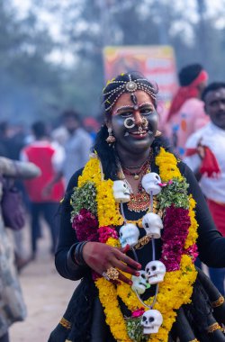 Kulashekharapatnam, Tamilnadu, Hindistan - 12 Ekim 2024: Yüzü boyalı ve tanrı karakteri gibi giyinmiş Hintli Hintli Hindu dindarın portresi kulasai dasara festivalinin ayinlerini gerçekleştirmek için.