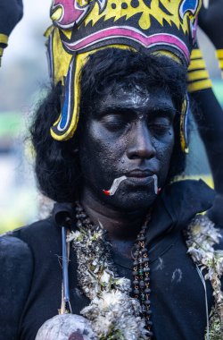 Kulashekharapatnam, Tamilnadu, Hindistan - 12 Ekim 2024: Yüzü boyalı ve tanrı karakteri gibi giyinmiş Hintli Hintli Hindu dindarın portresi kulasai dasara festivalinin ayinlerini gerçekleştirmek için.