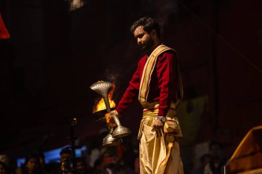 Varanasi, Uttar Pradesh, Hindistan - 20 Ocak 2024: Ganga aarti, Geleneksel elbise içinde Dashashwamedh ghat kutsal nehir keneviri akşam ayini yapan kimliği belirsiz genç bir erkek rahibin portresi.