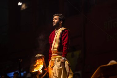 Varanasi, Uttar Pradesh, Hindistan - 20 Ocak 2024: Ganga aarti, Geleneksel elbise içinde Dashashwamedh ghat kutsal nehir keneviri akşam ayini yapan kimliği belirsiz genç bir erkek rahibin portresi.