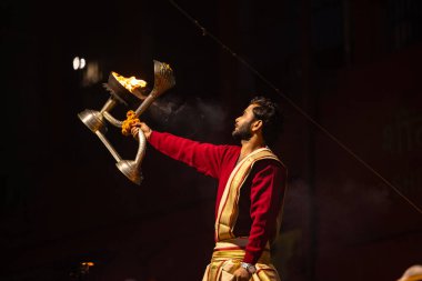 Varanasi, Uttar Pradesh, Hindistan - 20 Ocak 2024: Ganga aarti, Geleneksel elbise içinde Dashashwamedh ghat kutsal nehir keneviri akşam ayini yapan kimliği belirsiz genç bir erkek rahibin portresi.