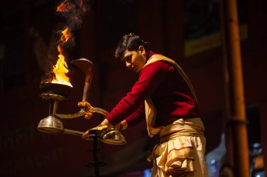 Varanasi, Uttar Pradesh, Hindistan - 20 Ocak 2024: Ganga aarti, Geleneksel elbise içinde Dashashwamedh ghat kutsal nehir keneviri akşam ayini yapan kimliği belirsiz genç bir erkek rahibin portresi.