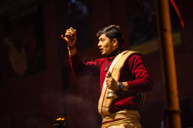 Varanasi, Uttar Pradesh, Hindistan - 20 Ocak 2024: Ganga aarti, Geleneksel elbise içinde Dashashwamedh ghat kutsal nehir keneviri akşam ayini yapan kimliği belirsiz genç bir erkek rahibin portresi.
