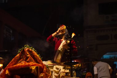 Varanasi, Uttar Pradesh, Hindistan - 20 Ocak 2024: Ganga aarti, Geleneksel elbise içinde Dashashwamedh ghat kutsal nehir keneviri akşam ayini yapan kimliği belirsiz genç bir erkek rahibin portresi.