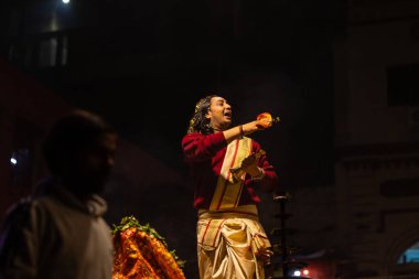 Varanasi, Uttar Pradesh, Hindistan - 20 Ocak 2024: Ganga aarti, Geleneksel elbise içinde Dashashwamedh ghat kutsal nehir keneviri akşam ayini yapan kimliği belirsiz genç bir erkek rahibin portresi.