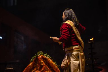 Varanasi, Uttar Pradesh, Hindistan - 20 Ocak 2024: Ganga aarti, Geleneksel elbise içinde Dashashwamedh ghat kutsal nehir keneviri akşam ayini yapan kimliği belirsiz genç bir erkek rahibin portresi.