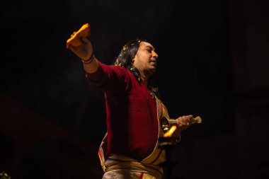 Varanasi, Uttar Pradesh, Hindistan - 20 Ocak 2024: Ganga aarti, Geleneksel elbise içinde Dashashwamedh ghat kutsal nehir keneviri akşam ayini yapan kimliği belirsiz genç bir erkek rahibin portresi.