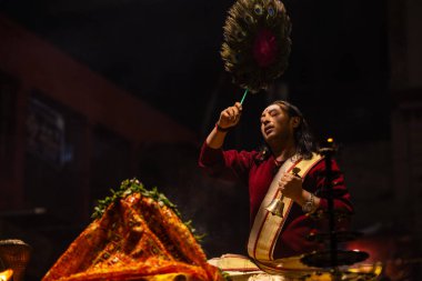Varanasi, Uttar Pradesh, Hindistan - 20 Ocak 2024: Ganga aarti, Geleneksel elbise içinde Dashashwamedh ghat kutsal nehir keneviri akşam ayini yapan kimliği belirsiz genç bir erkek rahibin portresi.