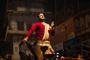 Varanasi, Uttar Pradesh, Hindistan - 20 Ocak 2024: Ganga aarti, Geleneksel elbise içinde Dashashwamedh ghat kutsal nehir keneviri akşam ayini yapan kimliği belirsiz genç bir erkek rahibin portresi.