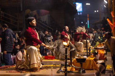 Varanasi, Uttar Pradesh, Hindistan - 20 Ocak 2024: Ganga aarti, Geleneksel elbise içinde Dashashwamedh ghat kutsal nehir keneviri akşam ayini yapan kimliği belirsiz genç bir erkek rahibin portresi.