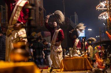 Varanasi, Uttar Pradesh, Hindistan - 20 Ocak 2024: Ganga aarti, Geleneksel elbise içinde Dashashwamedh ghat kutsal nehir keneviri akşam ayini yapan kimliği belirsiz genç bir erkek rahibin portresi.