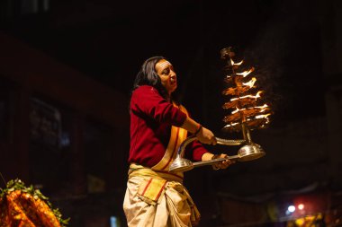 Varanasi, Uttar Pradesh, Hindistan - 20 Ocak 2024: Ganga aarti, Geleneksel elbise içinde Dashashwamedh ghat kutsal nehir keneviri akşam ayini yapan kimliği belirsiz genç bir erkek rahibin portresi.
