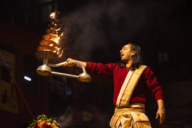 Varanasi, Uttar Pradesh, Hindistan - 20 Ocak 2024: Ganga aarti, Geleneksel elbise içinde Dashashwamedh ghat kutsal nehir keneviri akşam ayini yapan kimliği belirsiz genç bir erkek rahibin portresi.