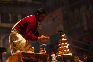 Varanasi, Uttar Pradesh, Hindistan - 20 Ocak 2024: Ganga aarti, Geleneksel elbise içinde Dashashwamedh ghat kutsal nehir keneviri akşam ayini yapan kimliği belirsiz genç bir erkek rahibin portresi.