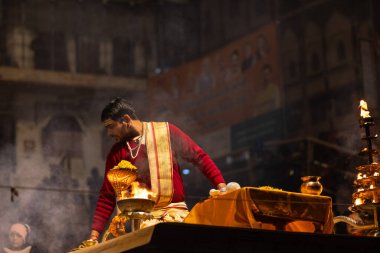 Varanasi, Uttar Pradesh, Hindistan - 20 Ocak 2024: Ganga aarti, Geleneksel elbise içinde Dashashwamedh ghat kutsal nehir keneviri akşam ayini yapan kimliği belirsiz genç bir erkek rahibin portresi.