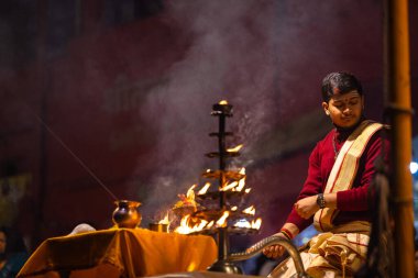Varanasi, Uttar Pradesh, Hindistan - 20 Ocak 2024: Ganga aarti, Geleneksel elbise içinde Dashashwamedh ghat kutsal nehir keneviri akşam ayini yapan kimliği belirsiz genç bir erkek rahibin portresi.
