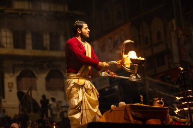 Varanasi, Uttar Pradesh, Hindistan - 20 Ocak 2024: Ganga aarti, Geleneksel elbise içinde Dashashwamedh ghat kutsal nehir keneviri akşam ayini yapan kimliği belirsiz genç bir erkek rahibin portresi.