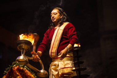Varanasi, Uttar Pradesh, Hindistan - 20 Ocak 2024: Ganga aarti, Geleneksel elbise içinde Dashashwamedh ghat kutsal nehir keneviri akşam ayini yapan kimliği belirsiz genç bir erkek rahibin portresi.