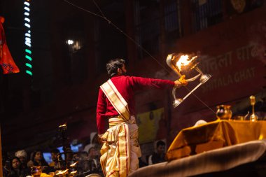 Varanasi, Uttar Pradesh, Hindistan - 20 Ocak 2024: Ganga aarti, Geleneksel elbise içinde Dashashwamedh ghat kutsal nehir keneviri akşam ayini yapan kimliği belirsiz genç bir erkek rahibin portresi.