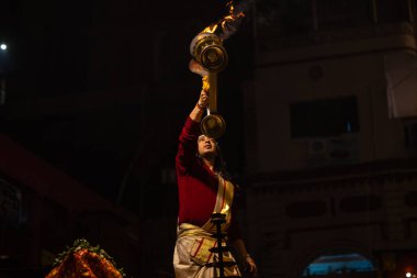 Varanasi, Uttar Pradesh, Hindistan - 20 Ocak 2024: Ganga aarti, Geleneksel elbise içinde Dashashwamedh ghat kutsal nehir keneviri akşam ayini yapan kimliği belirsiz genç bir erkek rahibin portresi.