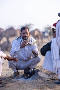 Puşkar, Rajasthan, Hindistan - 10 Kasım 2024: Deve ticareti karşılığında deve fuarı sırasında çöl fuarındaki Rajasthani erkeklerinin portresi.