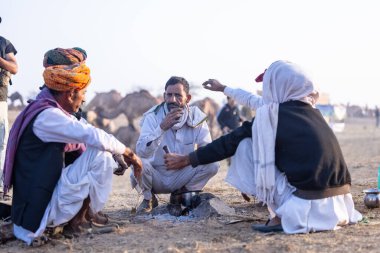 Puşkar, Rajasthan, Hindistan - 10 Kasım 2024: Deve ticareti karşılığında deve fuarı sırasında çöl fuarındaki Rajasthani erkeklerinin portresi.