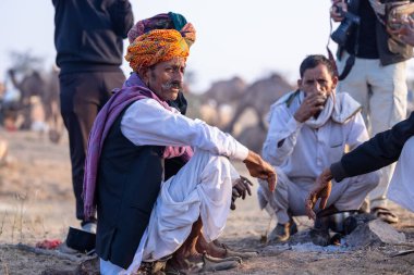 Puşkar, Rajasthan, Hindistan - 10 Kasım 2024: Deve ticareti karşılığında deve fuarı sırasında çöl fuarındaki Rajasthani erkeklerinin portresi.