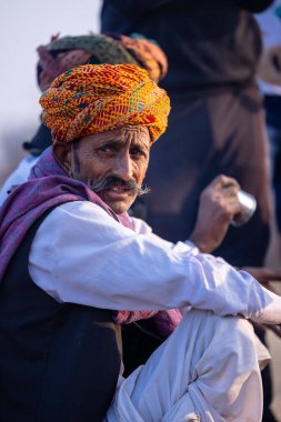 Puşkar, Rajasthan, Hindistan - 10 Kasım 2024: Deve ticareti karşılığında deve fuarı sırasında çöl fuarındaki Rajasthani erkeklerinin portresi.
