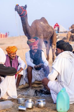 Puşkar, Rajasthan, Hindistan - 10 Kasım 2024: Deve ticareti karşılığında deve fuarı sırasında çöl fuarındaki Rajasthani erkeklerinin portresi.