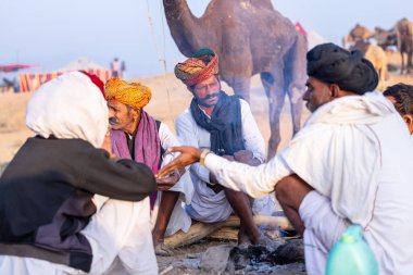 Puşkar, Rajasthan, Hindistan - 10 Kasım 2024: Deve ticareti karşılığında deve fuarı sırasında çöl fuarındaki Rajasthani erkeklerinin portresi.
