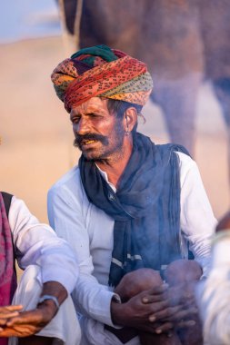 Puşkar, Rajasthan, Hindistan - 10 Kasım 2024: Deve ticareti karşılığında deve fuarı sırasında çöl fuarındaki Rajasthani erkeklerinin portresi.