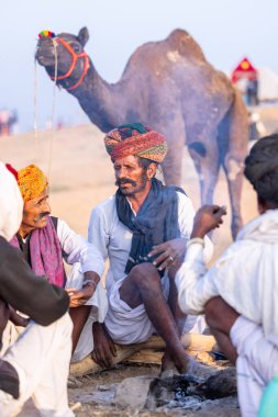 Puşkar, Rajasthan, Hindistan - 10 Kasım 2024: Deve ticareti karşılığında deve fuarı sırasında çöl fuarındaki Rajasthani erkeklerinin portresi.