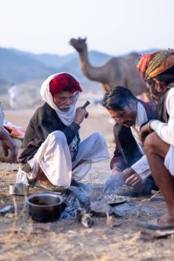 Puşkar, Rajasthan, Hindistan - 10 Kasım 2024: Deve ticareti karşılığında deve fuarı sırasında çöl fuarındaki Rajasthani erkeklerinin portresi.
