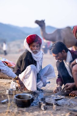 Puşkar, Rajasthan, Hindistan - 10 Kasım 2024: Deve ticareti karşılığında deve fuarı sırasında çöl fuarındaki Rajasthani erkeklerinin portresi.