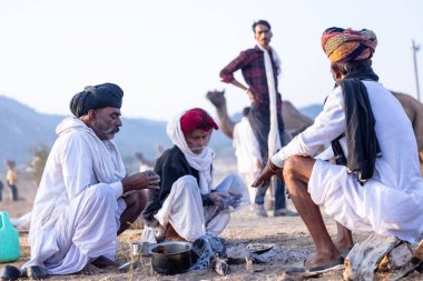 Puşkar, Rajasthan, Hindistan - 10 Kasım 2024: Deve ticareti karşılığında deve fuarı sırasında çöl fuarındaki Rajasthani erkeklerinin portresi.