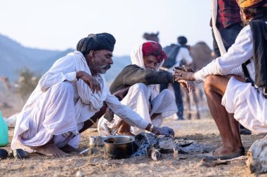 Puşkar, Rajasthan, Hindistan - 10 Kasım 2024: Deve ticareti karşılığında deve fuarı sırasında çöl fuarındaki Rajasthani erkeklerinin portresi.