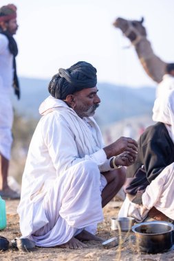 Puşkar, Rajasthan, Hindistan - 10 Kasım 2024: Deve ticareti karşılığında deve fuarı sırasında çöl fuarındaki Rajasthani erkeklerinin portresi.