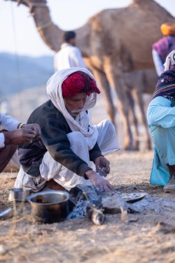 Puşkar, Rajasthan, Hindistan - 10 Kasım 2024: Deve ticareti karşılığında deve fuarı sırasında çöl fuarındaki Rajasthani erkeklerinin portresi.