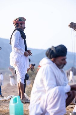 Puşkar, Rajasthan, Hindistan - 10 Kasım 2024: Deve ticareti karşılığında deve fuarı sırasında çöl fuarındaki Rajasthani erkeklerinin portresi.