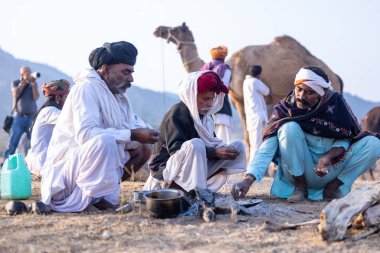 Puşkar, Rajasthan, Hindistan - 10 Kasım 2024: Deve ticareti karşılığında deve fuarı sırasında çöl fuarındaki Rajasthani erkeklerinin portresi.